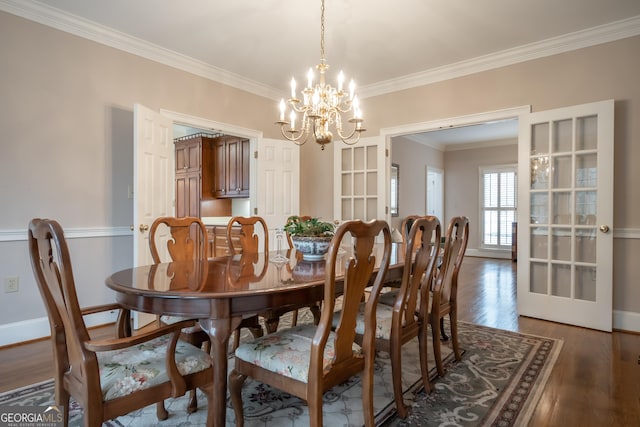 dining room with baseboards, crown molding, a chandelier, and wood finished floors