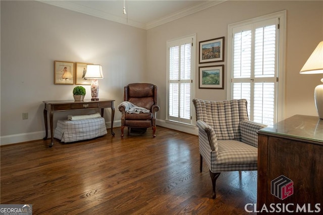 living area featuring ornamental molding, wood finished floors, and baseboards