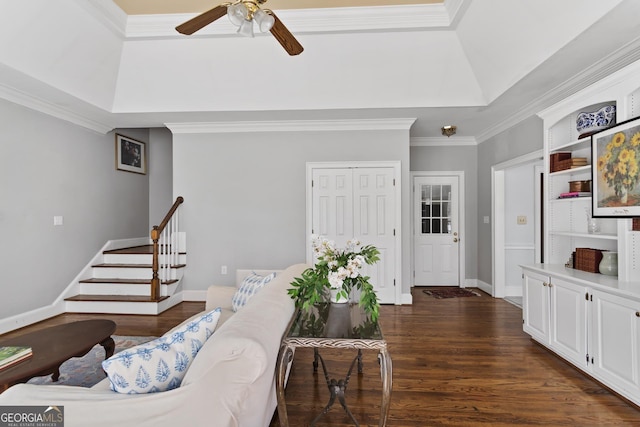 living area with stairway, ceiling fan, ornamental molding, and dark wood-style flooring