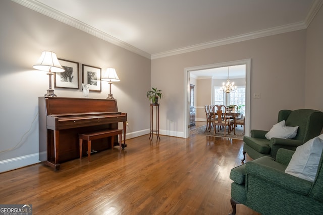 sitting room featuring ornamental molding, an inviting chandelier, baseboards, and wood finished floors