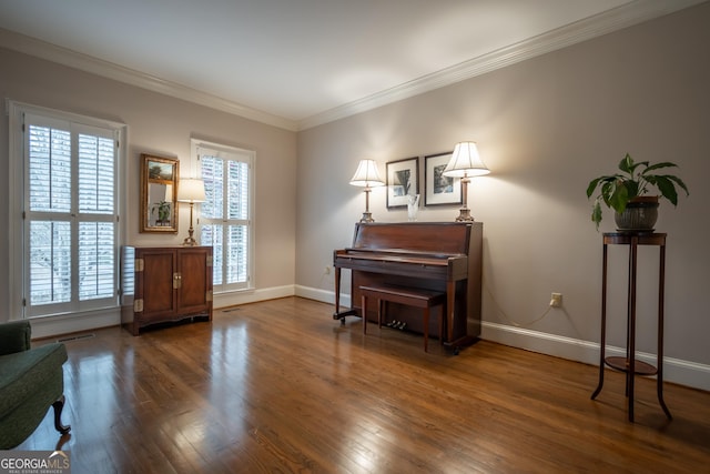 sitting room with baseboards, ornamental molding, and wood finished floors