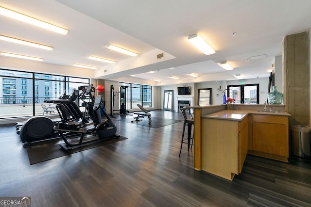 workout area featuring indoor wet bar, a fireplace, a sink, and visible vents