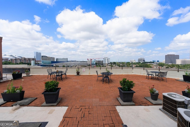 view of patio / terrace with a view of city, outdoor dining space, and central AC unit