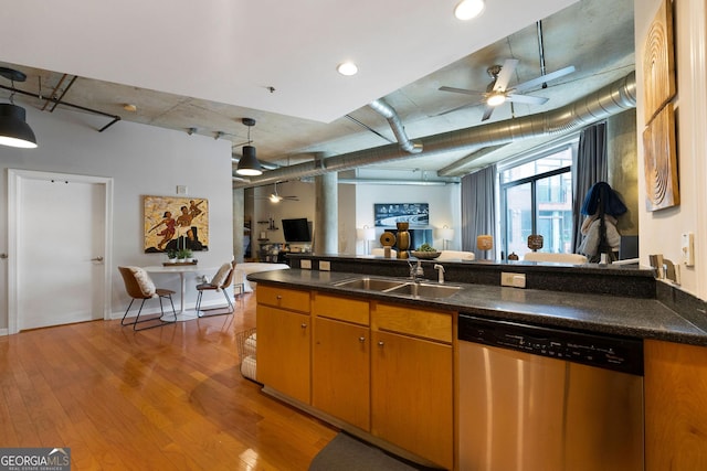 kitchen with ceiling fan, a sink, light wood-style floors, stainless steel dishwasher, and dark countertops