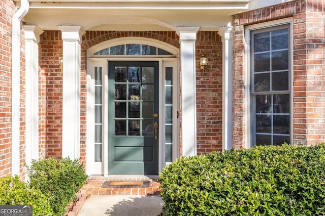 property entrance featuring brick siding