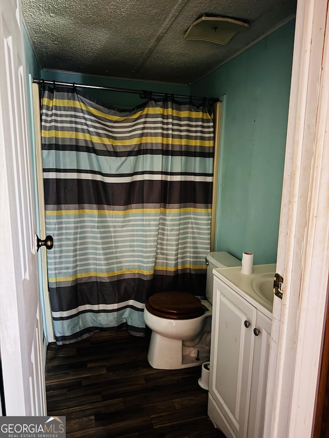 full bath with a shower with shower curtain, toilet, a textured ceiling, vanity, and wood finished floors