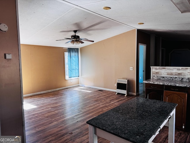 kitchen with baseboards, dark wood-style floors, ceiling fan, a center island, and heating unit