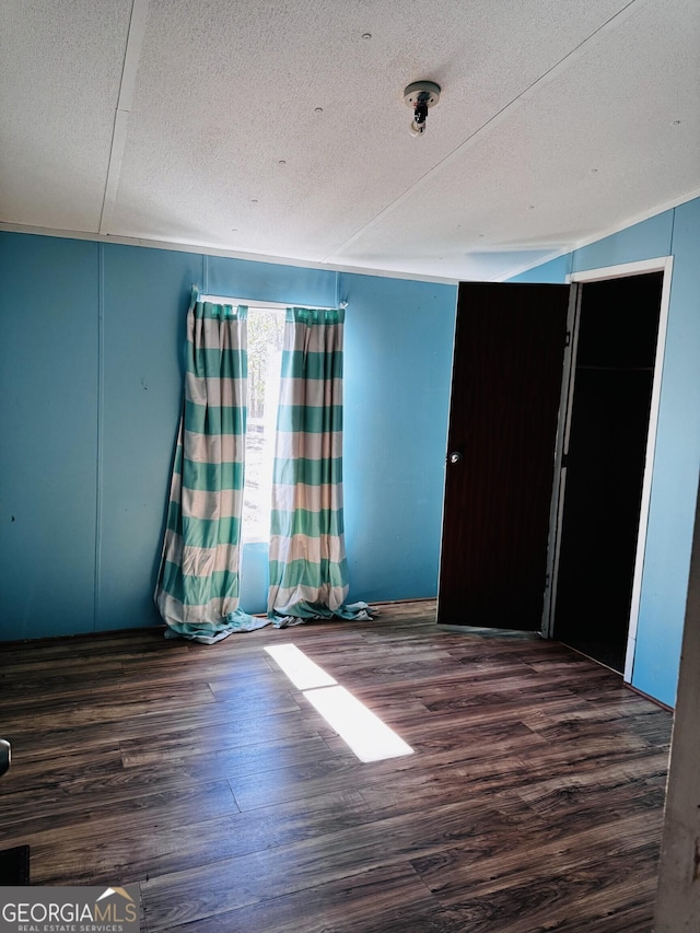 unfurnished bedroom featuring a textured ceiling and wood finished floors