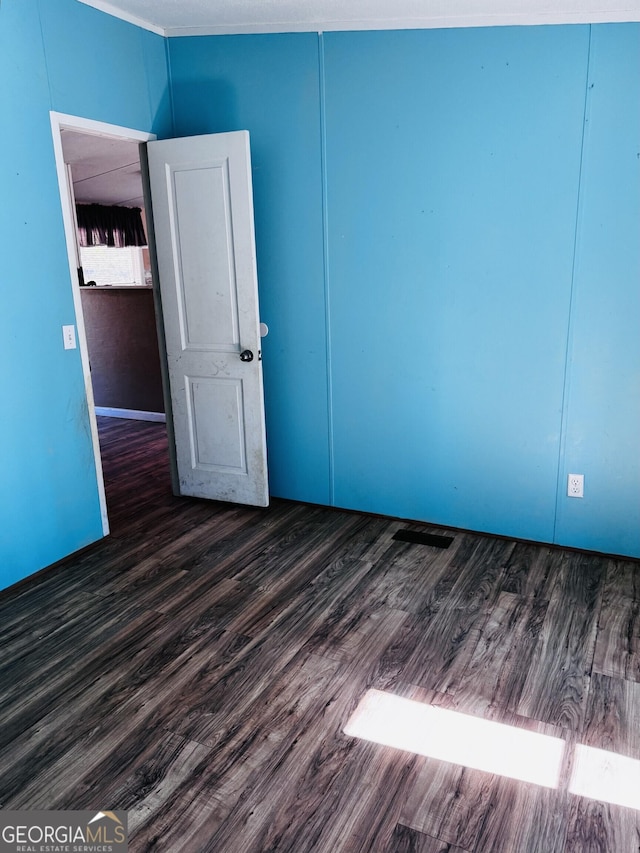 empty room with dark wood-type flooring