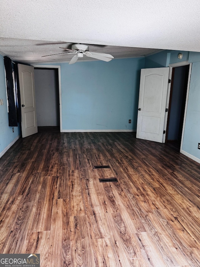 unfurnished room with dark wood-style floors, ceiling fan, a textured ceiling, and baseboards