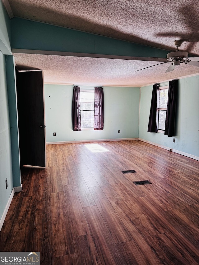 unfurnished room with a textured ceiling, visible vents, and wood finished floors