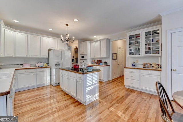 kitchen featuring white appliances, light wood-style flooring, white cabinets, and crown molding