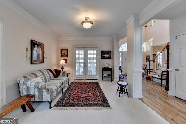 living room with french doors, crown molding, ornate columns, and stairs