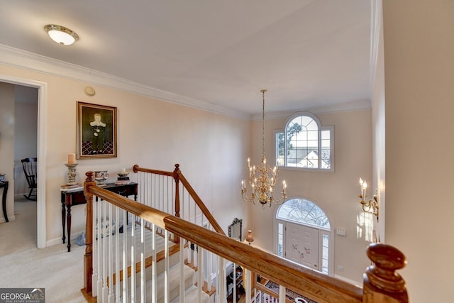 corridor featuring light colored carpet, crown molding, an upstairs landing, and an inviting chandelier