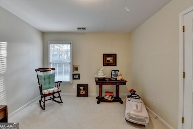 living area featuring baseboards, visible vents, and carpet flooring