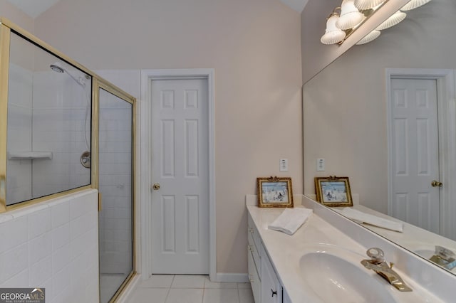 bathroom featuring a stall shower, vanity, baseboards, and tile patterned floors