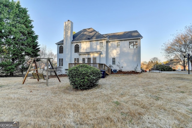 back of house with a chimney and a wooden deck