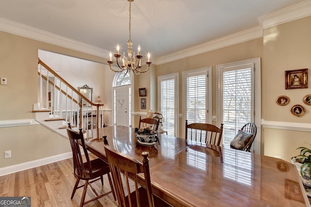 dining space featuring a notable chandelier, light wood-style flooring, ornamental molding, baseboards, and stairs