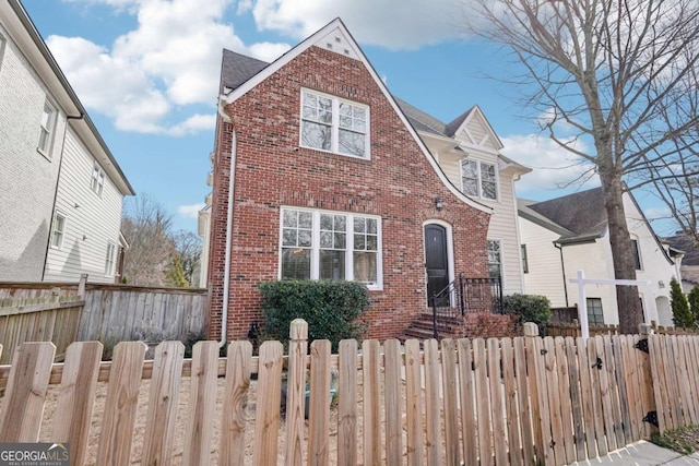 view of front of home with a fenced front yard and brick siding