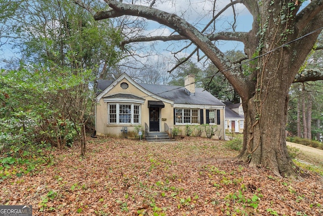 view of front facade featuring a chimney and brick siding