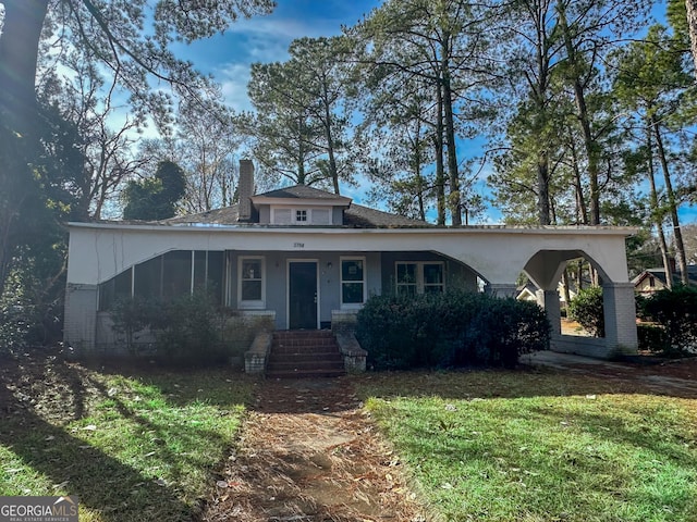 bungalow with a front yard and a chimney