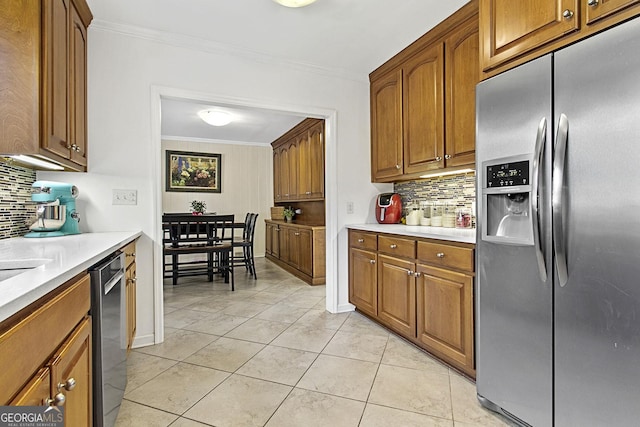 kitchen featuring ornamental molding, light countertops, appliances with stainless steel finishes, and light tile patterned floors