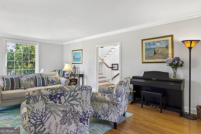 living area with baseboards, stairway, crown molding, and wood finished floors