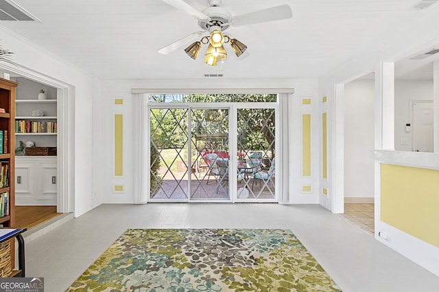 interior space with ceiling fan, visible vents, and ornamental molding