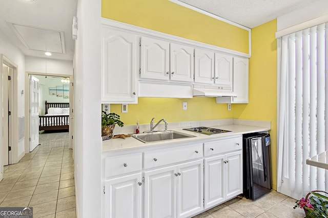 kitchen with light tile patterned floors, wine cooler, under cabinet range hood, a sink, and white cabinets