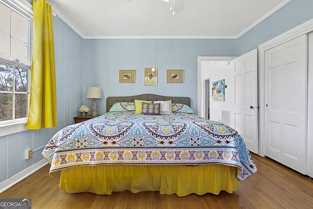 bedroom with ceiling fan, crown molding, and wood finished floors