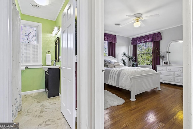 bedroom featuring ornamental molding, visible vents, baseboards, and wood finished floors