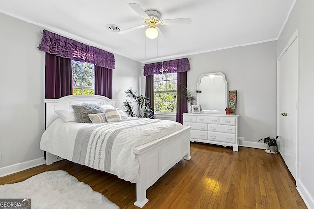 bedroom featuring ornamental molding, wood finished floors, visible vents, and baseboards