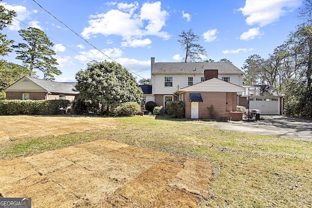 back of property featuring brick siding and a yard