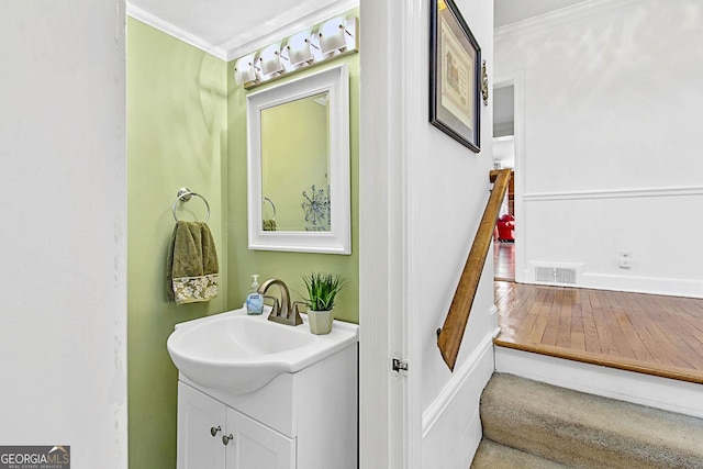 bathroom featuring visible vents, ornamental molding, and vanity