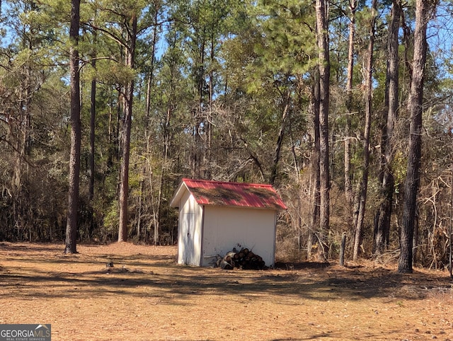 view of shed with a forest view