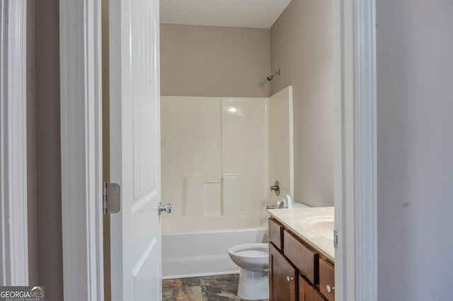 full bath featuring toilet, stone finish flooring, tub / shower combination, and vanity