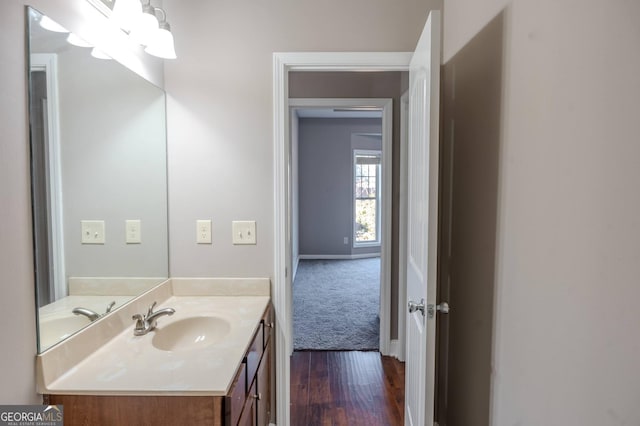 bathroom with vanity, baseboards, and wood finished floors