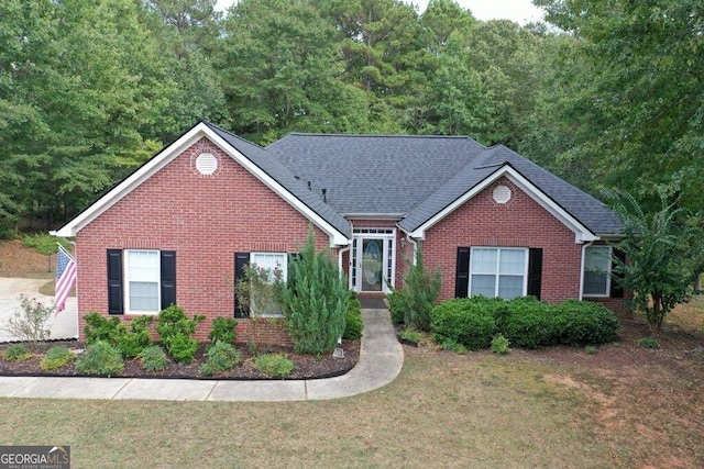 single story home with roof with shingles, brick siding, and a front lawn