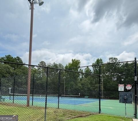 view of sport court featuring a lawn and fence