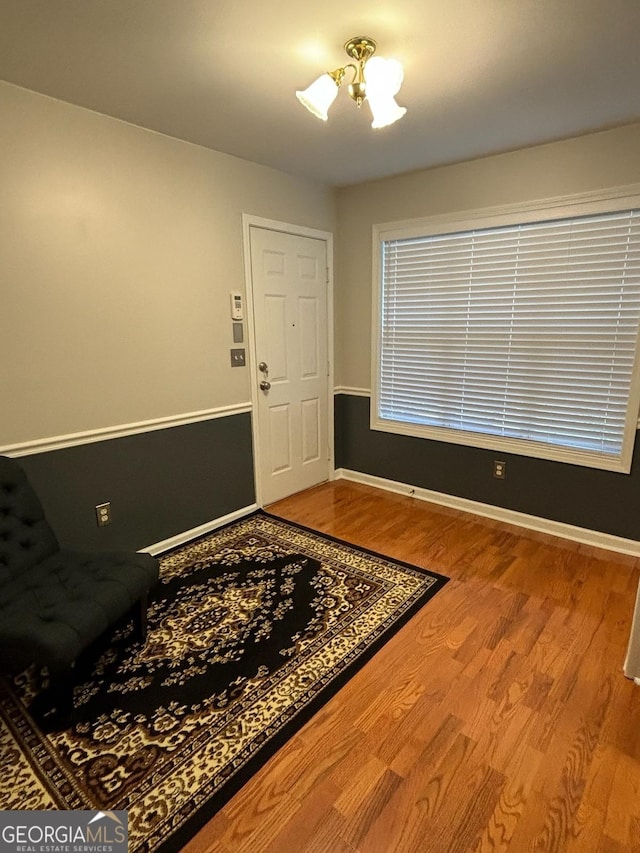 entryway with an inviting chandelier, baseboards, and wood finished floors