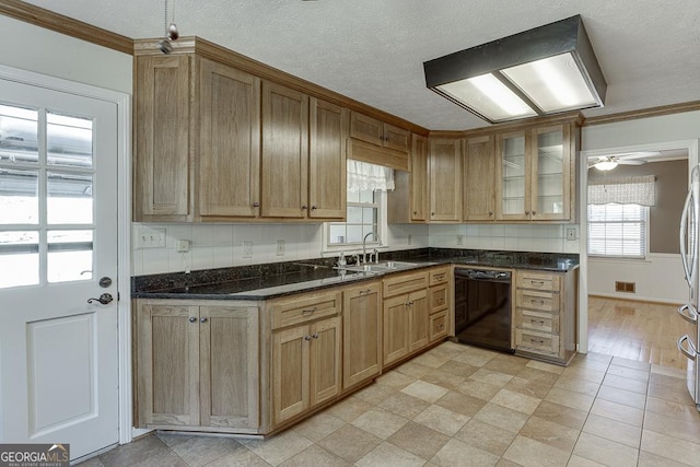 kitchen with black dishwasher, a sink, crown molding, glass insert cabinets, and freestanding refrigerator