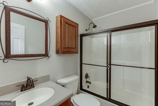 bathroom featuring a textured ceiling, toilet, vanity, shower / bath combination with glass door, and crown molding
