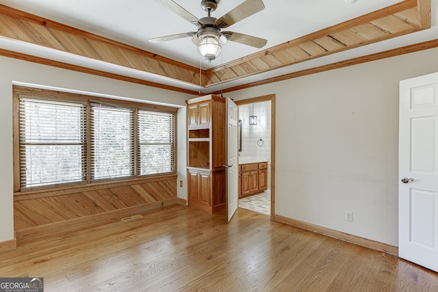 unfurnished room with a ceiling fan, baseboards, light wood-style floors, and crown molding