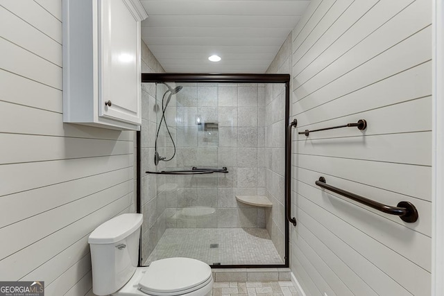 full bathroom featuring a stall shower, toilet, recessed lighting, and wooden walls