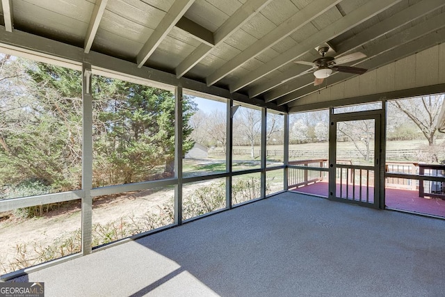 unfurnished sunroom featuring a ceiling fan and vaulted ceiling