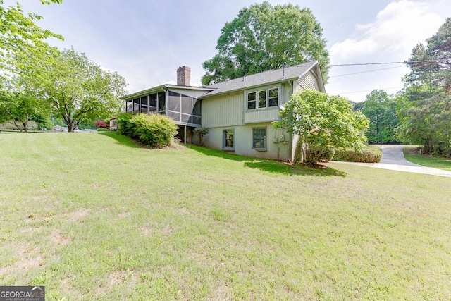 view of grassy yard with a sunroom