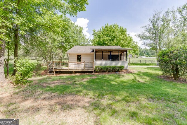 rear view of house with a deck and a sunroom
