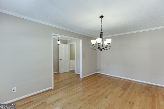 unfurnished dining area with light wood-type flooring, a chandelier, baseboards, and crown molding