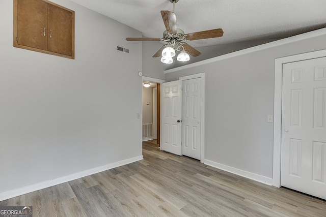 unfurnished dining area featuring ceiling fan, light wood-style flooring, baseboards, and lofted ceiling