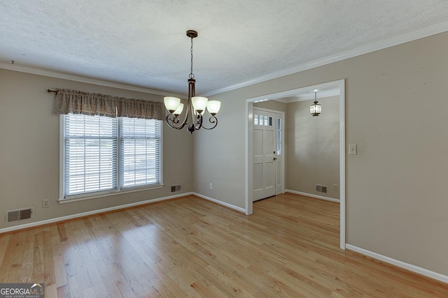 unfurnished dining area with a chandelier, a textured ceiling, baseboards, light wood finished floors, and ornamental molding